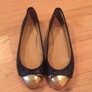 Black leather Talbot flats with gold toe.